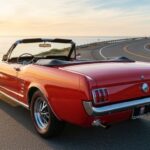 A beautiful red classic car insurance policy example, parked at sunset.