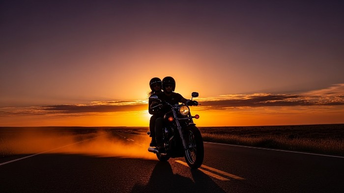 Couple riding into sunset with secure one day bike insurance cover