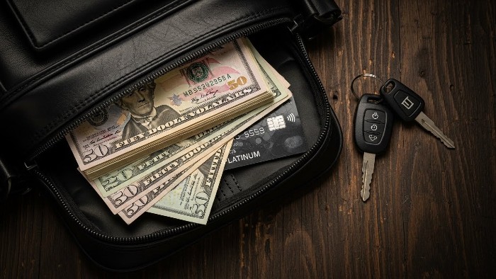 Cash and credit card with moto keys representing cheapest motorcycle insurance cost